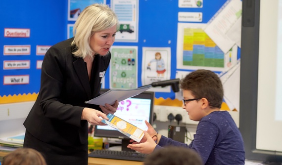 A bank employee with a student in a classroom