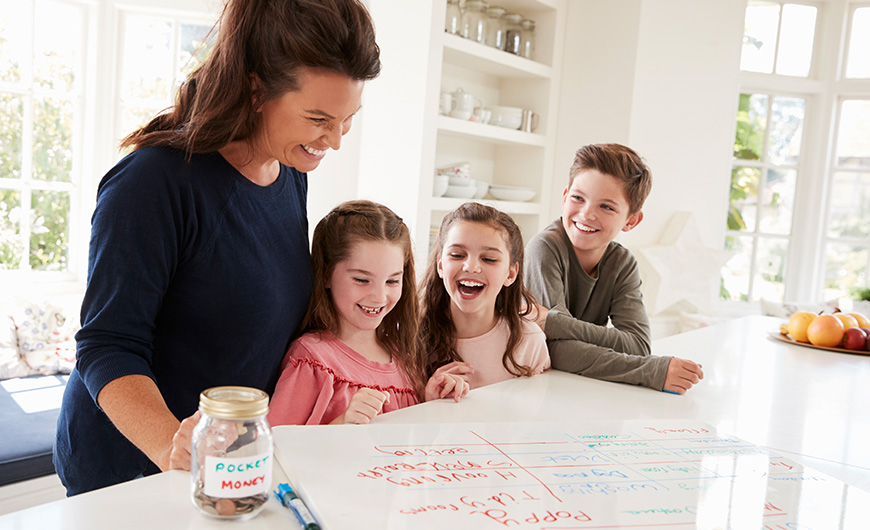 Children writing on a white board to decide how to spend their pocket money