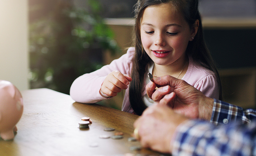 Young girl counts her coins on a table