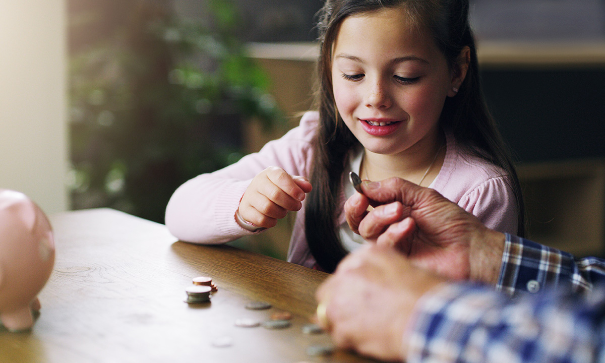 Young girl counts her coins on a table